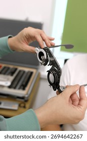 Trial frame for vision testing in a person's hands in an ophthalmology clinic.