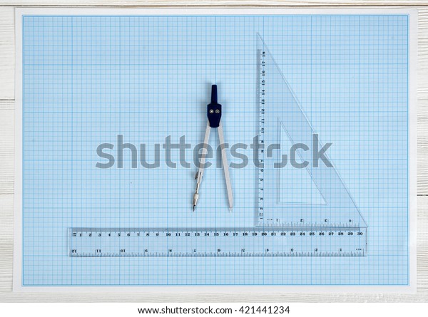 Triangle centimeter ruler, simple centimeter ruler\
and engineering divider on a blueprint. Top view composition.\
Measuring process. Work place of draftsman, architect, constructor.\
Engineering work
