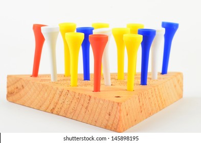 Triangle Peg Board Puzzle Or Golf Tee Game With Colorful Tees Against Neutral Background.