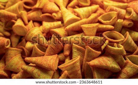 Triangle plain corn cone snacks, Corn cone pile. Bugles chips, puffs with spices, crunchy puffed snack