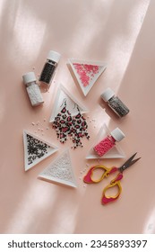 Triangular bead trays with beaded earrings. Different colored seed beads in containers for needlework and beading. Creativity and  hobby concept