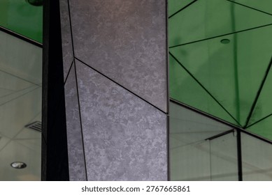 Triangular building details with green ceiling and black granite angular columns 