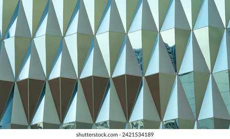 Triangular building facade made of green glass, glass facade of modern building, Modern office building glass An architectural detail in green tones. Abstraction.