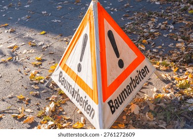 triangular german warning sign baumarbeiten, tree work ahead exclamation mark, public safety, winter maintenance urban or park trees, professional tree pruning, before new growth begins, trees trimmed