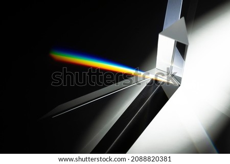 Triangular Prism dispersing sun beam splitting into a spectrum on white background