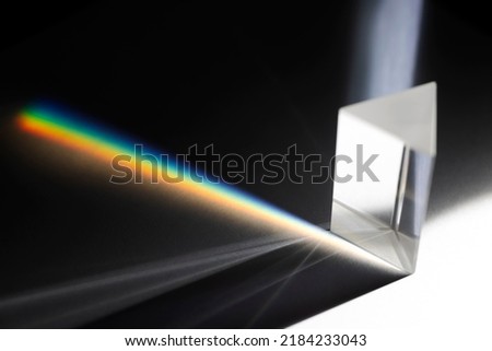 Triangular Prism dispersing sun beam splitting into a spectrum on white background