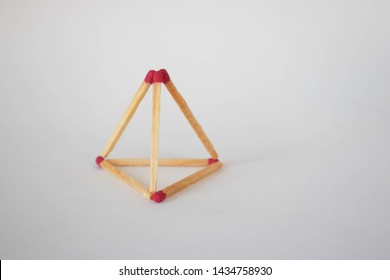 Triangular Pyramid Made With Matches On A White Backgourd