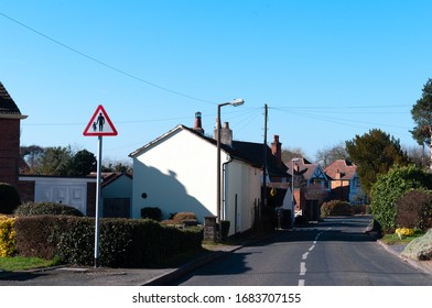 Triangular road safety warning sign for pedestrians in road or no footway. Isolated biside road. Lickey End, Bromsgrove.