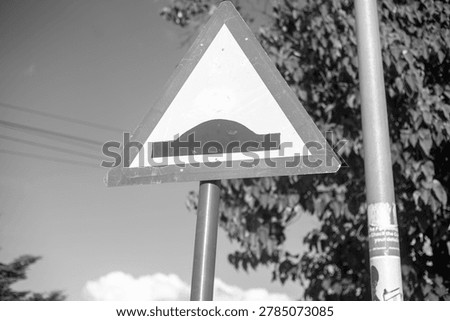 Triangular speed hump warning road sign.