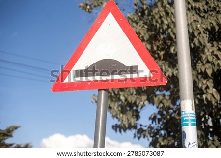 Triangular speed hump warning road sign.