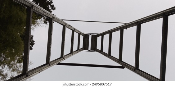 A triangular staircase is visible from below, creating a frog's eye view