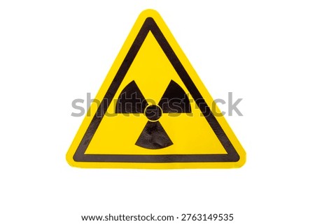 A triangular warning sign displays the radiation symbol. The bright yellow color and black design make it clear. This sign is used in areas with radiation hazards.
