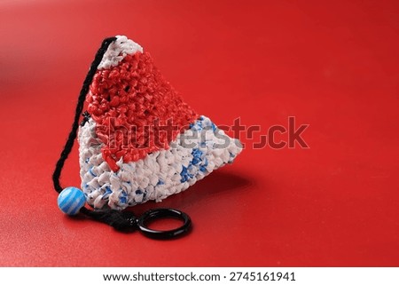 a triangular weave in a combination of white, red and blue on a minimalist bold red base