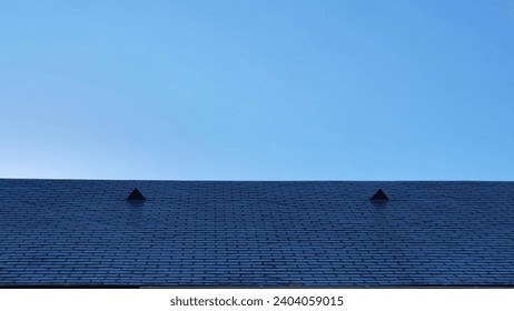 Triangular-shaped nedro roof in front of a cloudless blue sky