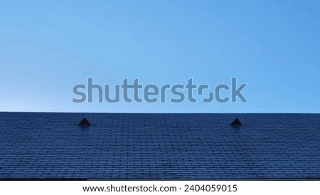 Triangular-shaped nedro roof in front of a cloudless blue sky
