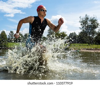 Ein Triathlet läuft aus dem Wasser