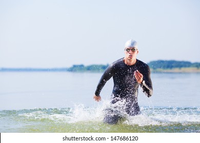 Triathlete Running Out Of The Water On Triathlon Race.