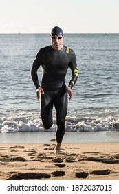 Triathlete Running Out Of The Water. Sport Concept