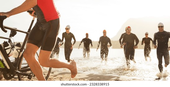 Triathlete swimmers emerging from water - Powered by Shutterstock