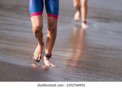 Triathletes Swimmers Running Out Of Ocean Finishing Swim Race. Fit Man Ending Swimming Sprinting Determined Out Of Water