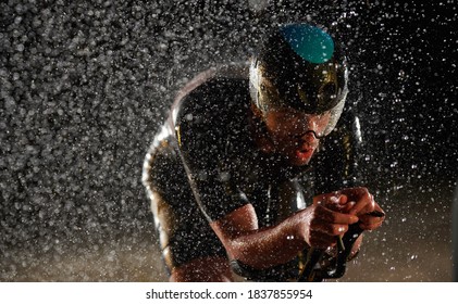 Triathlon Athlete Riding Bike Fast On Rainy Night