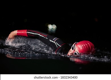 Triathlon Athlete Swimming In Dark Night Wearing Wetsuit