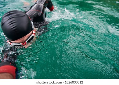 Triathlon Athlete Swimming On Lake Wearing Wetsuit