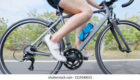 Triathlon Bike Training - Close Up Legs Of Asian Young Woman Is Riding A Bicycle With Water Bottle On The Road Concentratedly