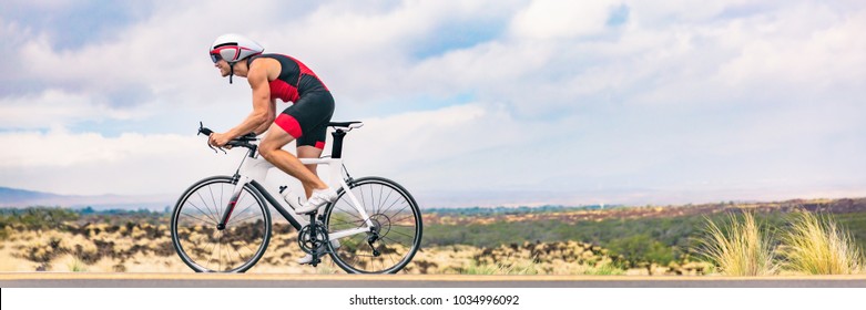 Triathlon Biking Man Cycling On Road Bike In Nature Background Banner. Cyclist Triathlete Riding Bicycle In Ironman Competition. Panorama Header Crop For Landscape Copy Space.