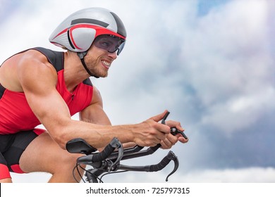 Triathlon Biking Man Cyclist Portrait Riding Bike. Male Triathlete Cycling On Triathlon Bike. Fit Man Professional Athlete On Triathlon Bicycle Wearing Time Trial Helmet For Ironman Race.