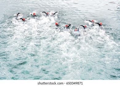  Triathlon Competitors In Swim , Triathletes In Action And Motion