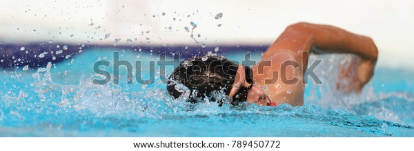 Triathlon fitness athlete\
training swimming in wave pool at gym health centre. Swimmer man\
swmming in blue water banner panorama. Sport and fitness cardio\
exercise.