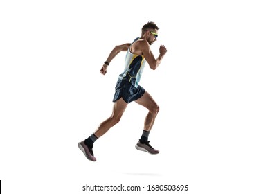Triathlon male athlete running isolated on white studio background. Caucasian fit jogger, triathlete training wearing sports equipment. Concept of healthy lifestyle, sport, action, motion. Side view.