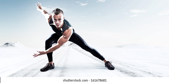 Triathlon Runner Man Outdoor In Winter Snow Landscape. Extreme Fitness Sport. Standing In Stretch Position. Warming Up.