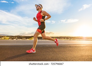 Triathlon - Triathlete man running in triathlon suit training for ironman race. Male runner exercising on Big Island Hawaii. Sunset.