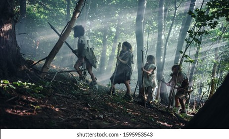 Tribe of Hunter-Gatherers Wearing Animal Skin Holding Stone Tipped Tools, Explore Prehistoric Forest in a Hunt for Animal Prey. Neanderthal Family Hunting in the Jungle or Migrating for Better Land - Shutterstock ID 1595953543