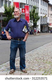 TRIBERG, GERMANY: JULY 12 2014: Man dressed in blue and purple waiting for a bus.