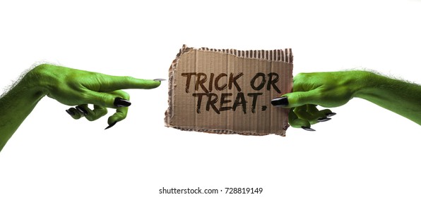 Trick or treat. green witches or zombie monster hand holding a halloween card sign