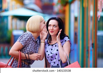 tricky young women gossip on the city street