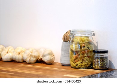 Tricolor spiral pasta and grain in glass jar with giant garlic in kitchen room. - Powered by Shutterstock