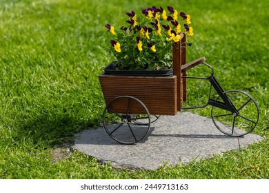 a tricycle decoration as a flower pot in a garden in the spring - Powered by Shutterstock