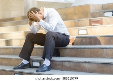 tried and stressed business man lost job sitting on ground street so sad and bad day,Business Stressed Concept