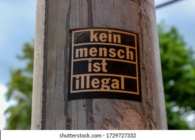 Trier, Rhineland-Palatinate, Germany - July 12, 2016: 'Kein Mensch ist illegal' sticker sticking on a street lamp in Germany/ German 'no human is illegal' sticker/ refugees welcome