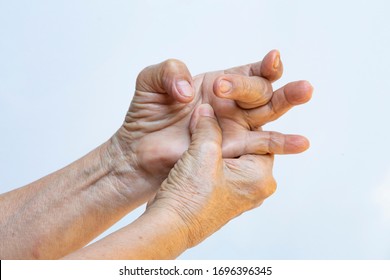 Trigger Finger lock on middle finger, Senior woman's right hand massaging her left hand Suffering from pain on white background, Close up shot, Office syndrome, Healthcare, Massage, Asian body concept