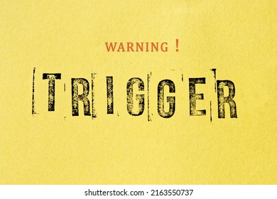 Trigger warning sign message on yellow background. Stamp letters mental triggering concept.