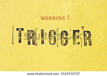 Trigger warning sign message on yellow background. Stamp letters mental triggering concept.