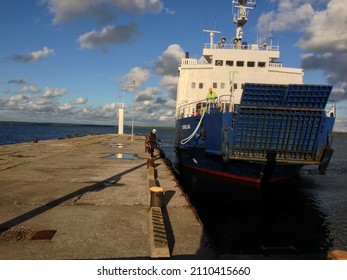 TRIIGI, ESTONIA - AUGUST 15 2013: A Crewmember On Board And A Dock Worker Handle The Lines To Tie Up Ro-Ro Car Ferry Korgelaid (IMO 8725577)  To Dock At Triigi Port.