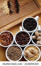 Trikatu plus spices and herbs: ginger, nutmeg, coriander, cayenne pepper, cloves and black pepper. Ayurvedic traditional herbal remedy. Whole ingredients in white cups on wooden background - Shutterstock ID 2136055325
