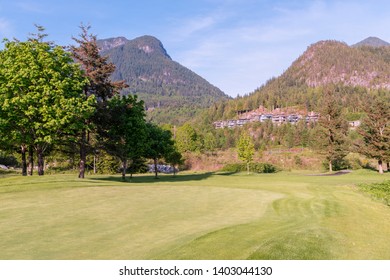 Trimmed Golf Course, Tall Trees, Private Houses And Cottages On The Mountainside, In The Woods, Against The Blue Sky