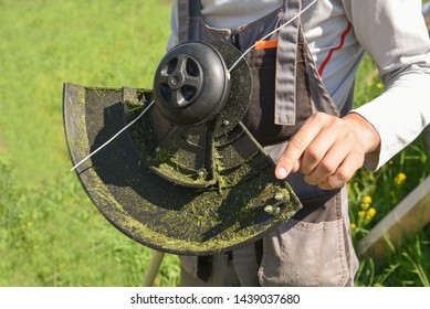 Trimmer close up mow the grass with a lawnmower. Gardening with a brush cutter Close-up. Lawn care with brush cutters. Male worker cleans the trimmer. mowing the lawn.